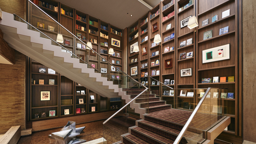 【中央大階段】壁一面に「銀座 蔦屋書店」選書の本が並ぶロビーの大階段