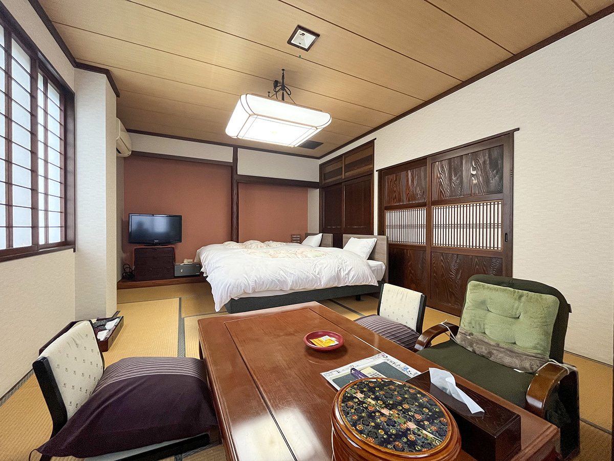 #ゆりの間　温かみのある木目と、アクセントカラーを用いた壁紙が調和した開放感のあるモダンな和室。