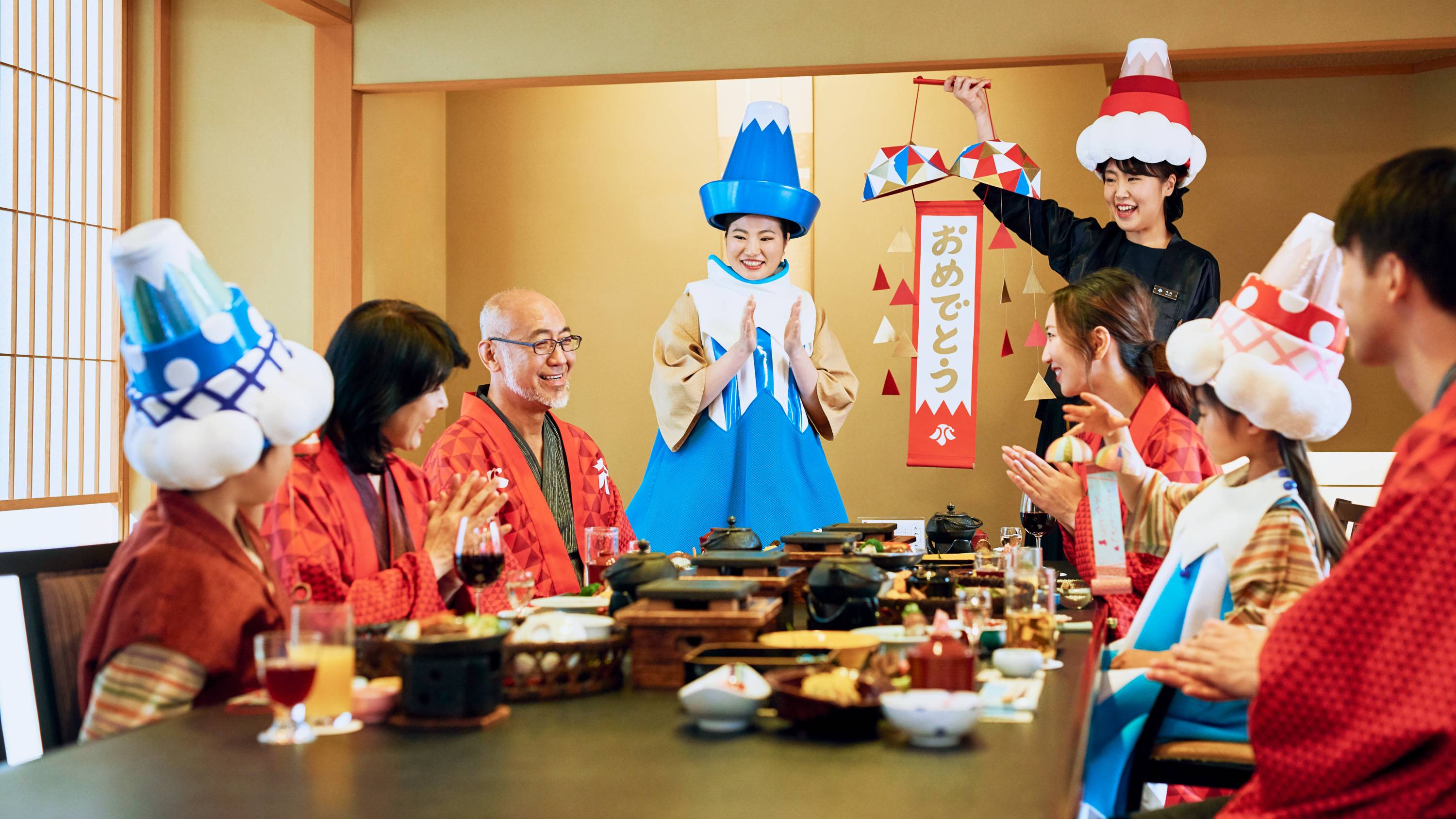 夕食の時間、スタッフもささやかなお祝いをお届けします。 富士山がデザインされた特性のくす玉と、おちゃめなかぶり物で、 スタッフも一緒に記念日をお祝いします。