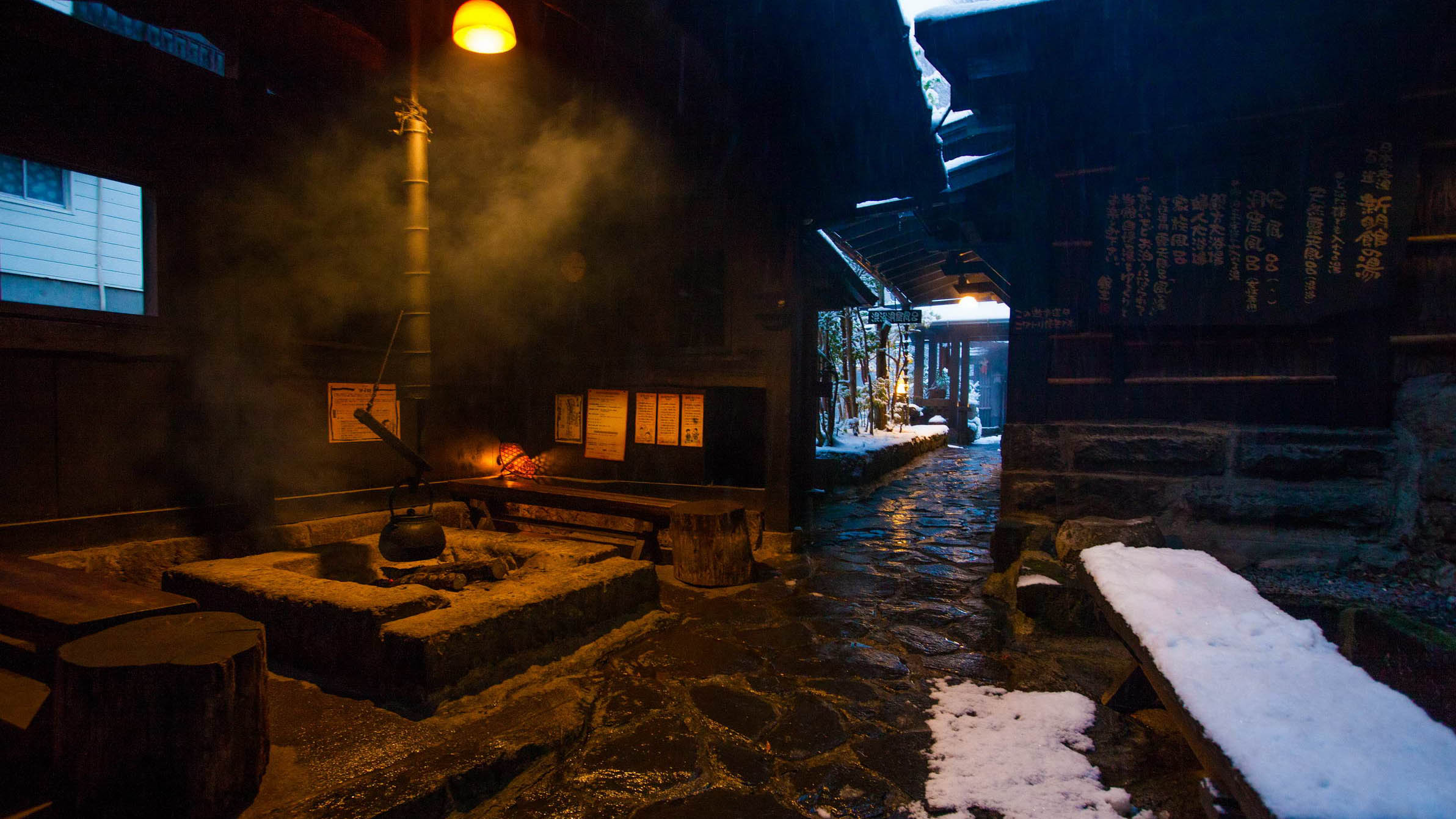 雪景色の中、薪の煙が立ちのぼる幻想的な囲炉裏