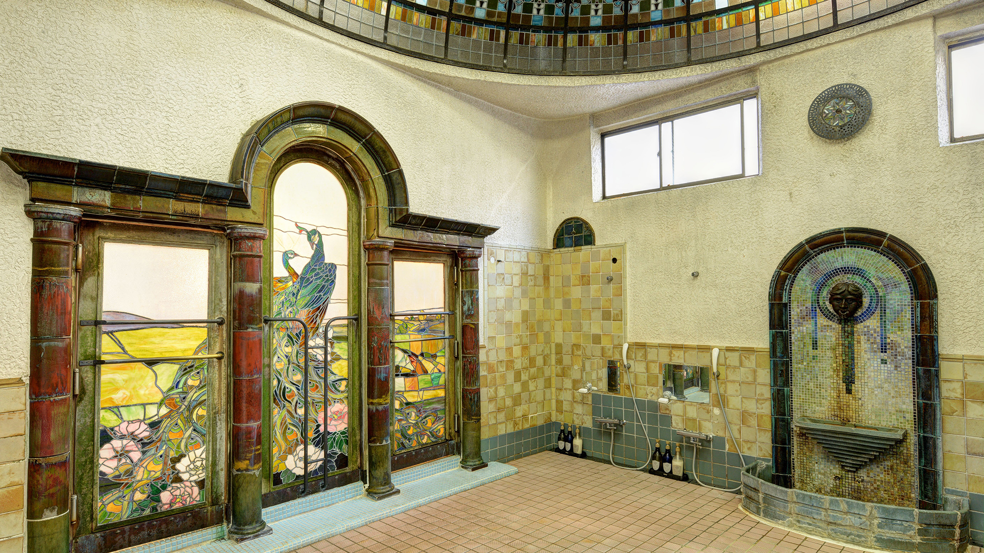 *【岩本楼ローマ風呂】浴場左手ベネチア窓風の壁泉は、中国古陶磁と釉薬研究で知られる小森忍の作品です。