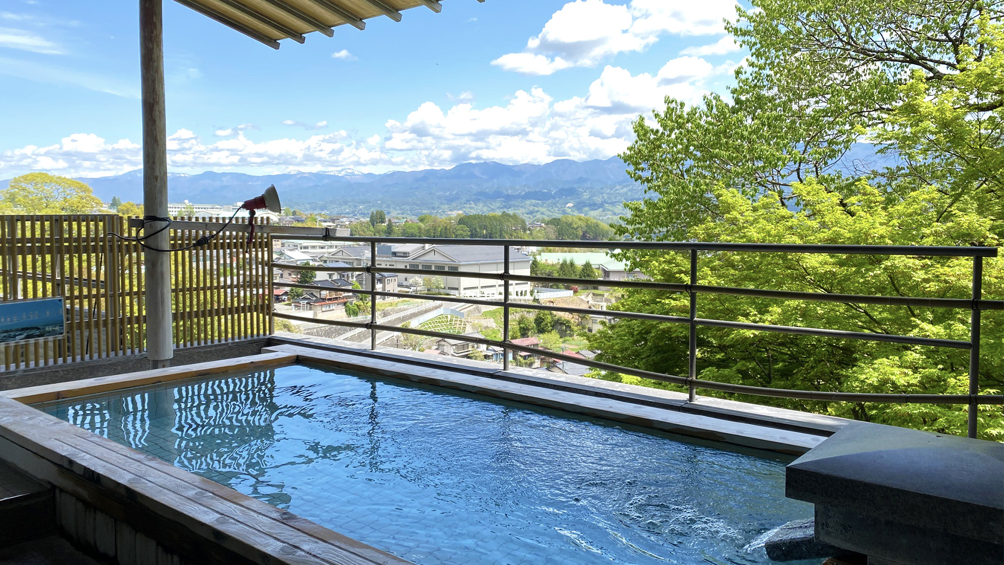 初夏の露天風呂からの眺め。美しい山の緑をご覧いただけます。