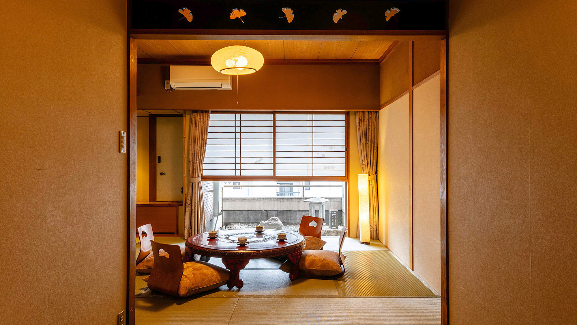 【スーペリア和室10畳】窓の外の小さな庭を眺め、ゆっくりとくつろぐ贅沢な時間。