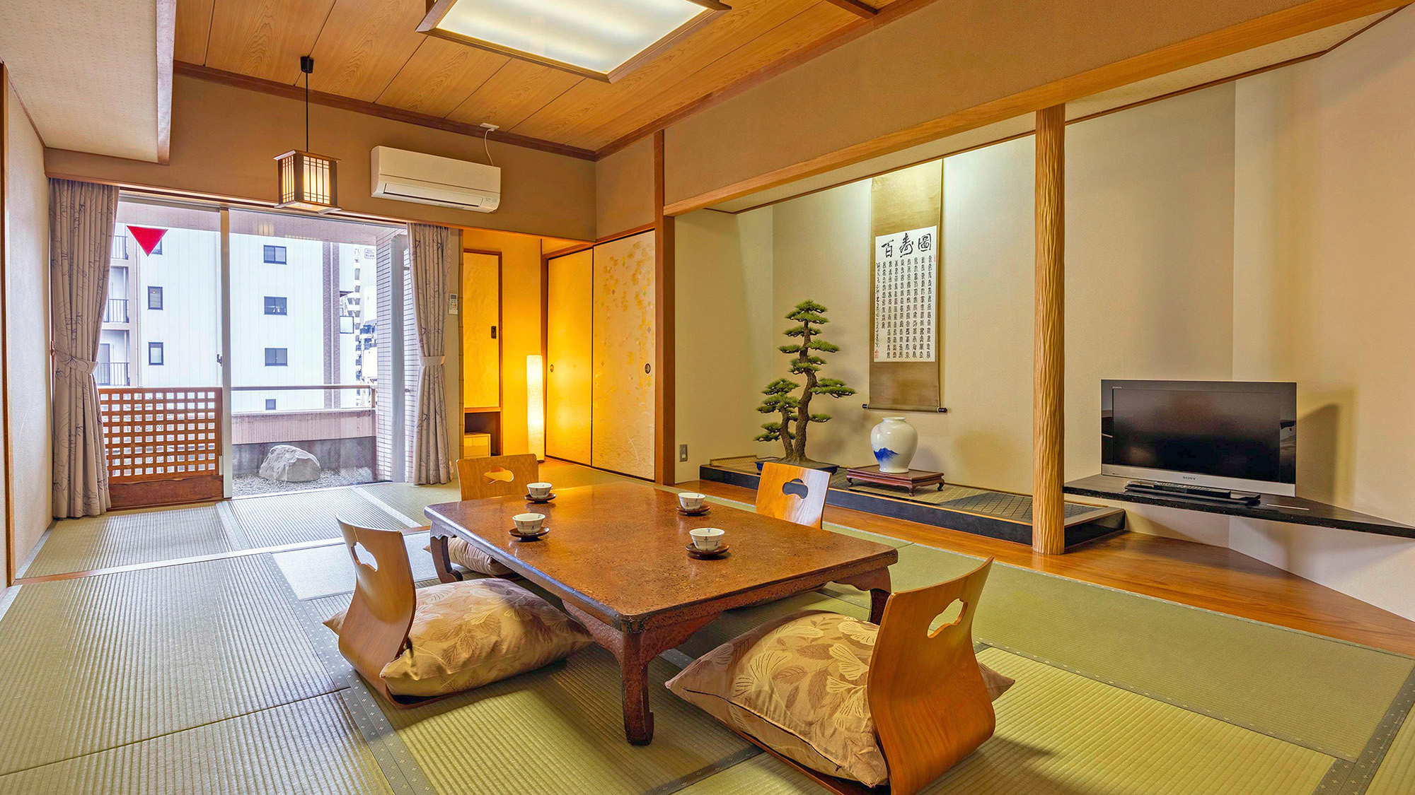 【スーペリア和室10畳】窓の外の小さな庭を眺め、ゆっくりとくつろぐ贅沢な時間。 