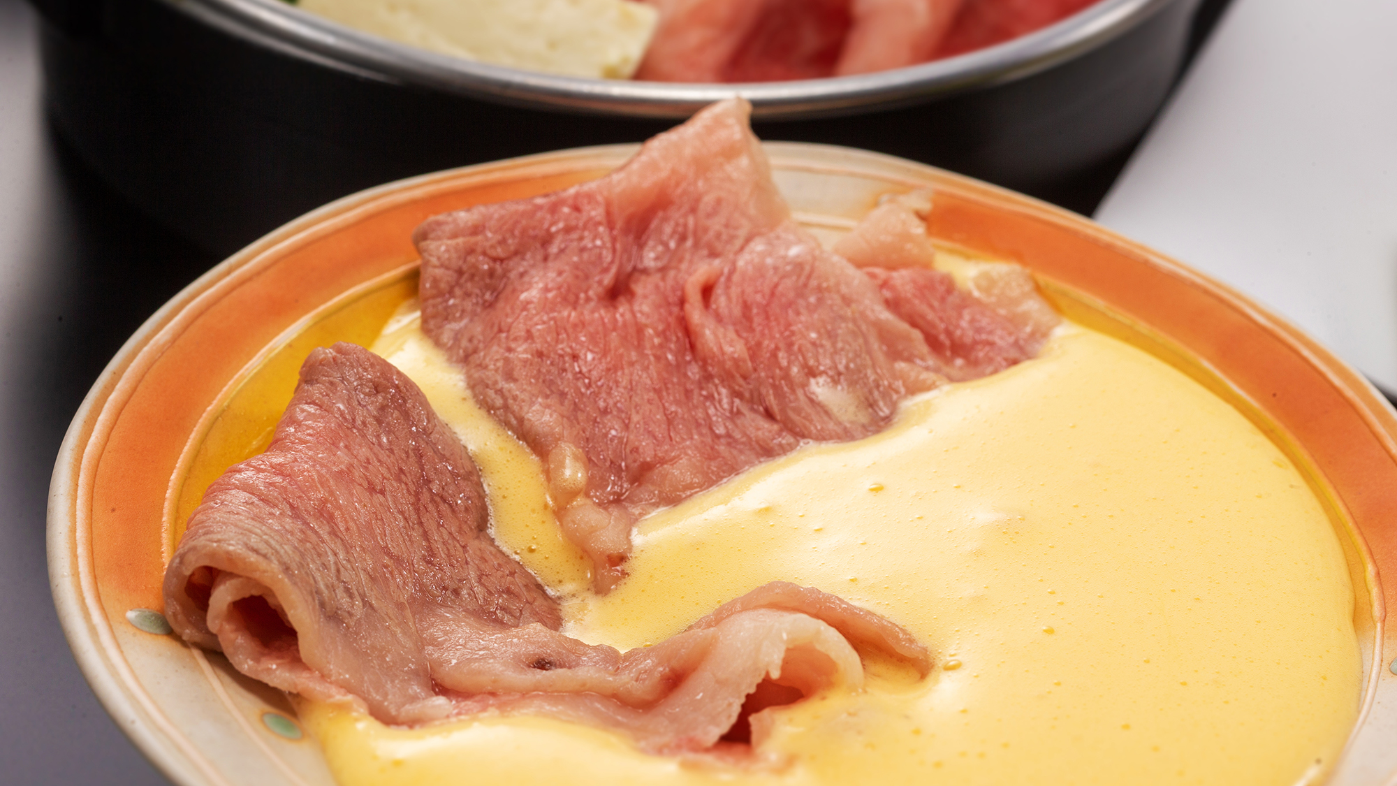 “濃厚なホイップ卵黄”を付けて食べるオリジナルすき焼き。こだわりお肉の新しい味わい方。