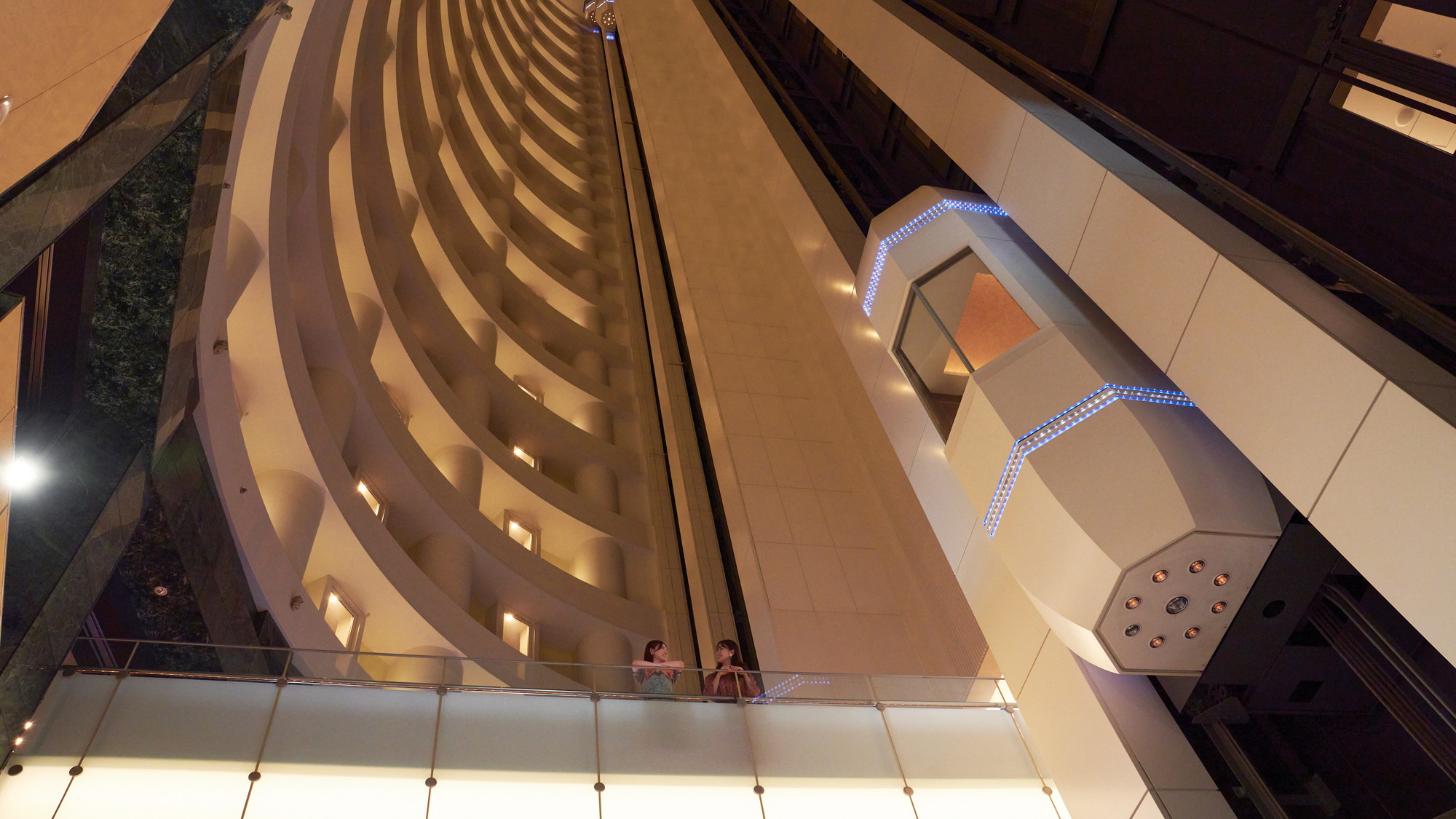【エレベーター】ロビーは高層階まで吹抜けとなっており、エレベーターから筒状の構造が感じられる。
