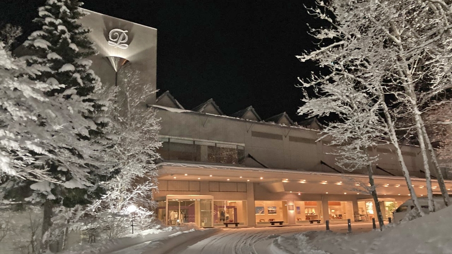 【外観】木々に積もった雪がホテルの灯に照らされた様子。